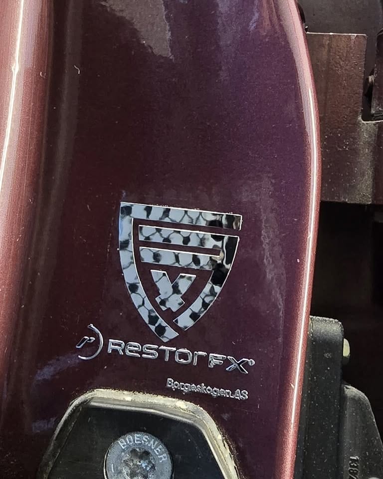 RestorFX-logo speilet i den blanke burgunderlakken på en BMW